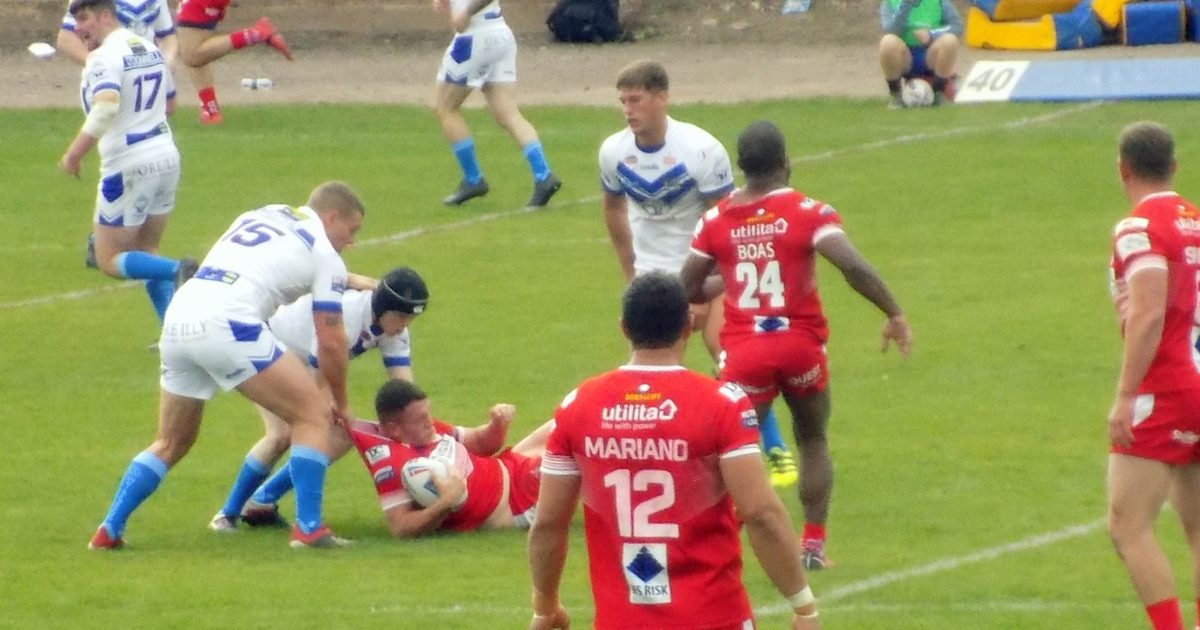 Workington roughly tackle the Doncaster ball carrier.